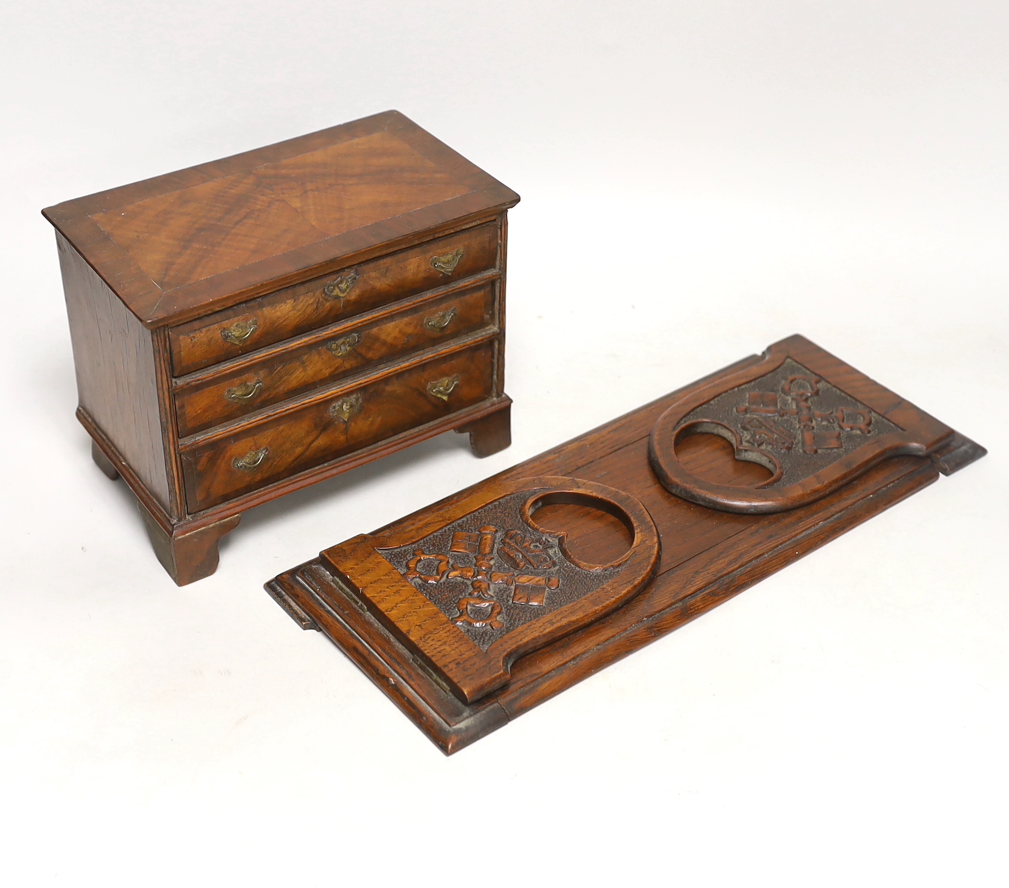 A miniature walnut chest of drawers and a bookslide, relating to the fire at York Minster, 34cm wide (closed)